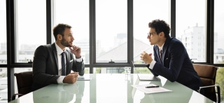 Two businessmen in focused meeting representing cultural alignment strategy in managed teams for ROI