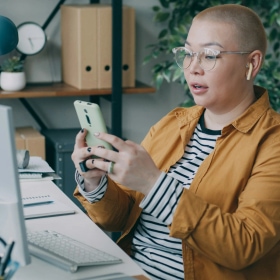 Woman working on phone at desk