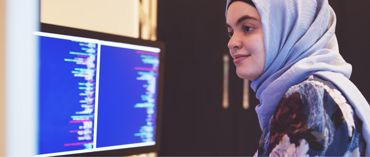 Women working remotely, coding on desktop screen