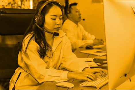 A woman and a man working on a computer in an office